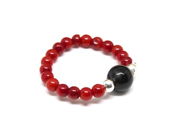 May include: A red coral beaded ring with a black gemstone and silver accents.