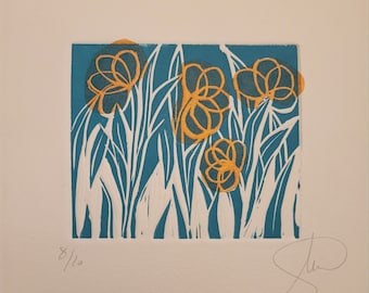 May include: A blue and white linocut print of stylized flowers with yellow centers. The print is signed and numbered 8/12.