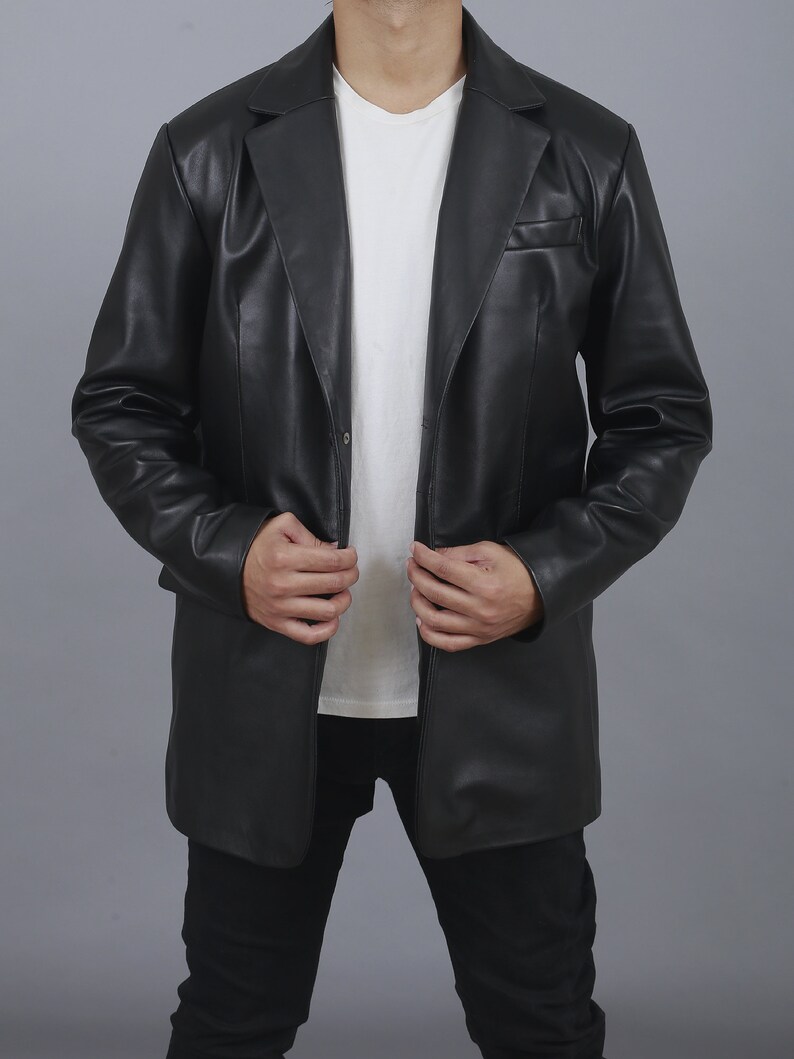 May include: A black leather blazer with a single button closure and a long, fitted silhouette.