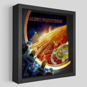 May include: A framed art print titled "Alien Frontiers" depicts a vibrant space scene. Astronauts in blue suits gaze out a window at a fiery planet, space stations, and distant planets. The artwork is set in a black frame.