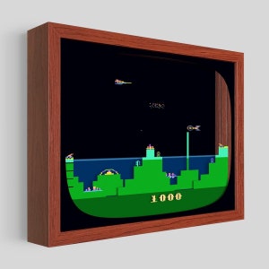 May include: A framed digital art print of a retro video game screen. The game is set in a dark space with a green landscape and a blue water line. The score is 1000.