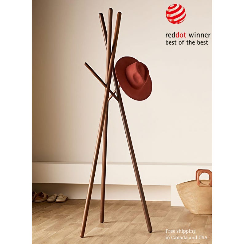 May include: A wooden coat rack with four branches extending from a tripod base. A brown hat hangs on one of the branches. The coat rack is made of dark wood and has a natural finish.