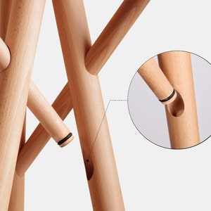 Puede incluir: Un perchero de madera con m&uacute;ltiples ramas que se conectan con un sistema de interbloqueo simple pero efectivo. Las ramas est&aacute;n hechas de madera natural y tienen un color marr&oacute;n claro.