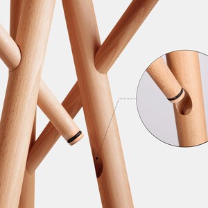 May include: A wooden coat rack with multiple branches, each with a black rubber ring at the end. The branches are connected by a unique interlocking system, shown in a close-up detail.