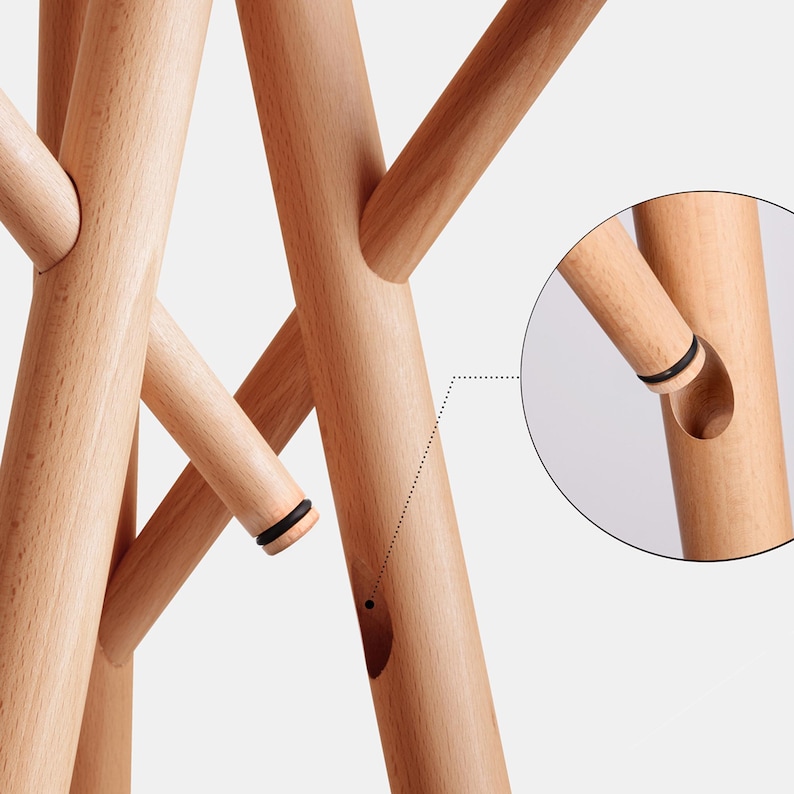 May include: A wooden coat rack with multiple branches, each with a black rubber ring at the end. The branches are connected by a unique interlocking system, shown in a close-up detail.