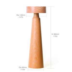 K&ouml;nnte beinhalten: Eine Holztischlampe mit nat&uuml;rlicher Holzoptik. Die Lampe ist 380 mm hoch und hat einen Durchmesser von 120 mm oben und einen Durchmesser von 90 mm unten.