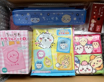 Könnte beinhalten: Eine Box voller japanischer Merchandise-Artikel mit Charakteren. Enthalten sind ein blaues Federmäppchen, eine rosa Tragetasche, eine Packung Magnete und andere farbenfrohe Verpackungen mit niedlichen Cartoon-Charakteren. Der Text "ちいかわ" ist auf mehreren Artikeln zu sehen.