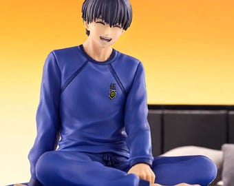 Puede incluir: Una figura de una persona con cabello oscuro y expresión sonriente, que viste una camiseta azul de manga larga y pantalones azules a juego. La camiseta presenta un pequeño emblema en el pecho con el carácter kanji para el número cinco.