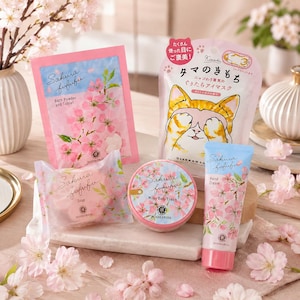 Può includere: Una collezione di prodotti per la cura della pelle Sakura fufufu che include una confezione di polvere e tavoletta da bagno, una maschera per gli occhi a tema gatto, una saponetta incartata, un barattolo rotondo di crema corpo e un tubetto di crema mani con fiori di ciliegio.