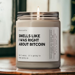 May include: A clear glass jar candle with a white label that reads "Smells Like I Was Right About Bitcoin". The candle is hand-poured soy blend and has a 50 hour burn time.