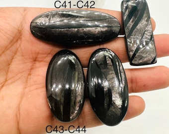 May include: Four black obsidian stones with silver streaks. Two stones are oval shaped and labeled C43-C44. One stone is rectangular and labeled C41-C42. The fourth stone is rectangular and unlabeled.