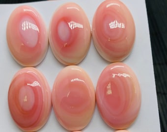 May include: Nine oval-shaped pink and white shell cabochons, each with a unique swirling pattern, arranged in three rows on a white surface. The text "20 x 30m" and "9P" are written on the surface.