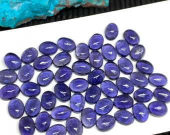 May include: A collection of 50 oval-shaped, purple amethyst gemstones. The gemstones are smooth and polished, with a slight sheen.
