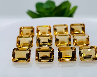 Puede incluir: Un grupo de doce piedras preciosas de color amarillo dorado, talladas en forma de esmeralda rectangular, dispuestas en tres filas sobre una superficie blanca.