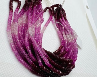 May include: A strand of pink and purple gemstone beads. The beads are faceted and have a gradient color from light pink to dark purple.