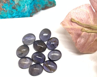 May include: Ten oval-shaped, purple-grey gemstones with a shimmery, iridescent finish.