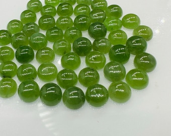 May include: A collection of round, green gemstone cabochons. The cabochons are smooth and polished, with a slight sheen.