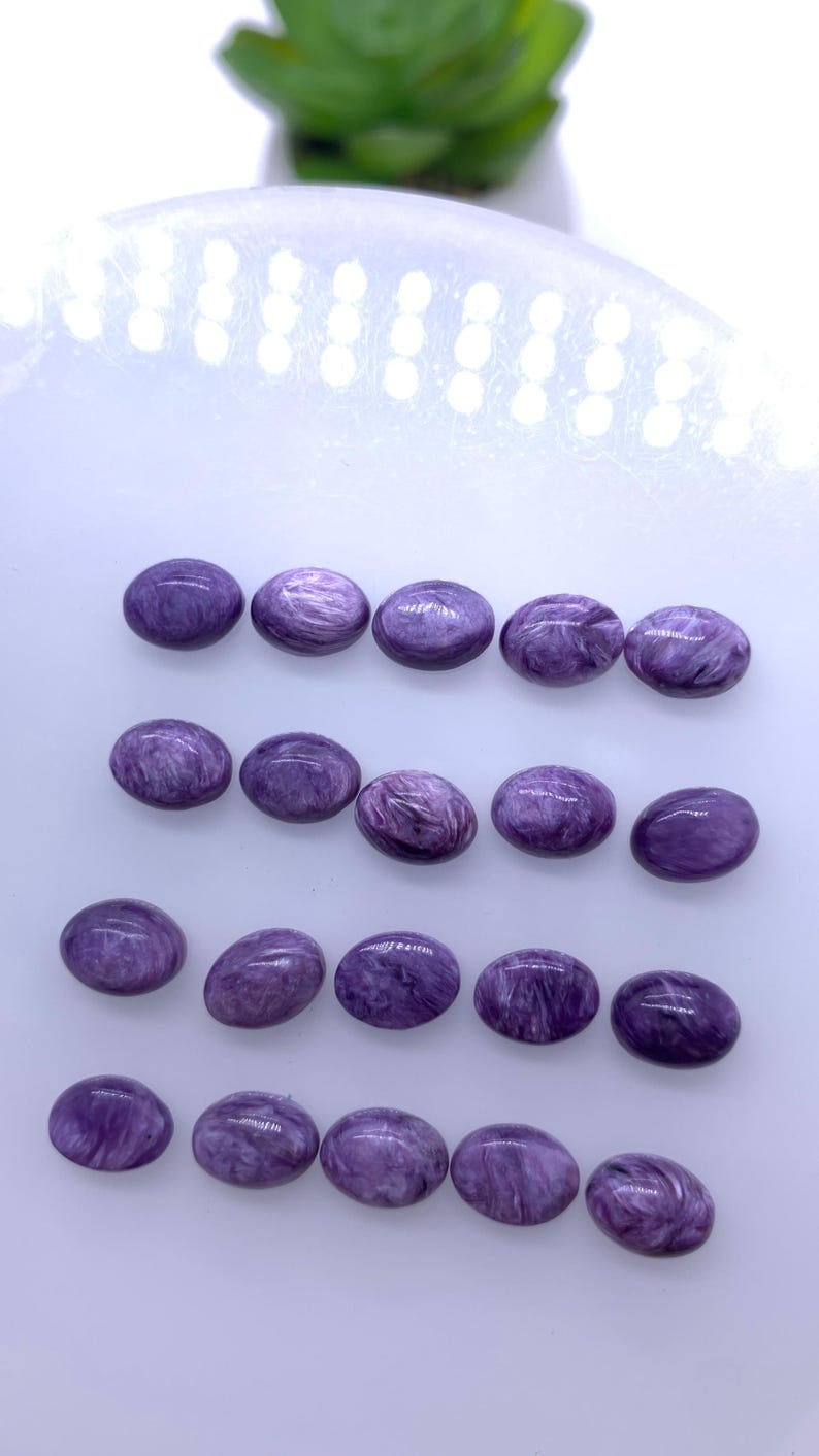 May include: Twenty oval-shaped purple gemstones with a swirling pattern.