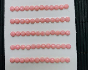 Könnte beinhalten: Auf einer weißen Karte sind mehrere Reihen kleiner, hellrosa Perlen mit einem Durchmesser von etwa 5 mm angeordnet. Die Karte ist mit "5mm" und "84pcs" beschriftet. Die Perlen sind gleichmäßig angeordnet und scheinen eine einheitliche Größe und Farbe zu haben.