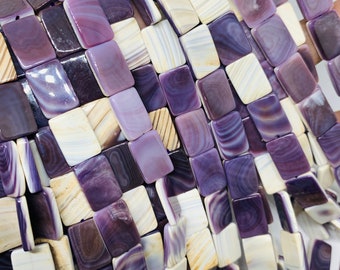 May include: A strand of purple and white shell beads, each bead is a square shape with a smooth, polished finish.