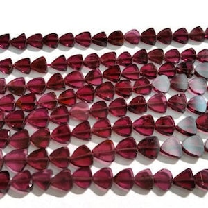 May include: A strand of deep red gemstone beads, each bead is a triangular shape with a slightly iridescent finish.