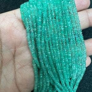 Puede incluir: Una hebra de cuentas de piedras preciosas de color verde esmeralda, facetadas y pulidas, enhebradas en un hilo. Las cuentas son pequeñas y de tamaño uniforme, creando un aspecto delicado y elegante.
