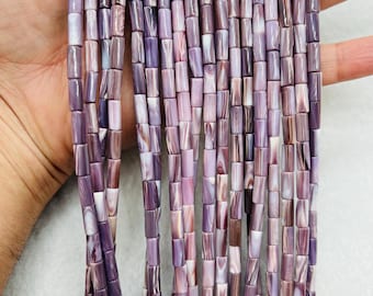 May include: A strand of purple and white shell beads, each bead is a cylinder shape.