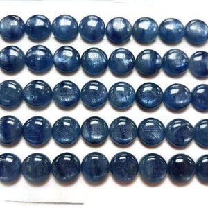 May include: A row of 30 round, blue gemstone beads. The beads are smooth and have a slight shimmer.