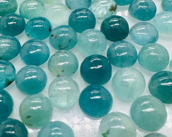 May include: A collection of round, cabochon-cut gemstones in shades of blue and green. The stones are smooth and polished, with a high gloss finish.