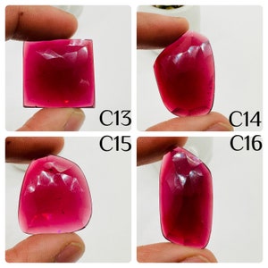 May include: Four close-up images of red gemstones with faceted surfaces. The gemstones are held in a hand and are displayed against a white background. The images are labeled C13, C14, C15, and C16.