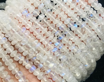 May include: A strand of white moonstone beads, each bead is a smooth, rounded oval shape with a slight iridescent shimmer.