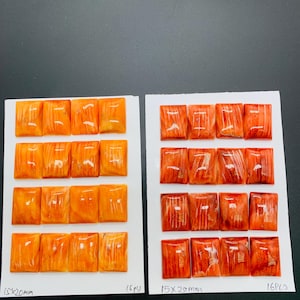 May include: Two sets of orange-colored, rectangular gemstones, each measuring 15x20mm, are displayed on white cards. Each card has 16 pieces. The gemstones have a polished, glossy finish, and the color varies from light to dark orange.