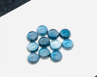 May include: Ten round, blue topaz cabochons, each with a slightly different shade of blue.
