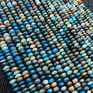 Op de afbeelding: Een streng blauwe, groene en bruine edelsteen kralen. De kralen zijn rond en hebben een gevlekt uiterlijk.