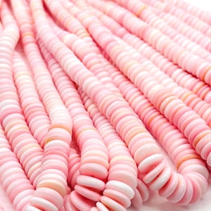 May include: Strands of pink shell beads. The beads are flat, round, and vary in shades of pink and white. The beads are strung together, creating a flowing, textured appearance. Ideal for jewelry making.