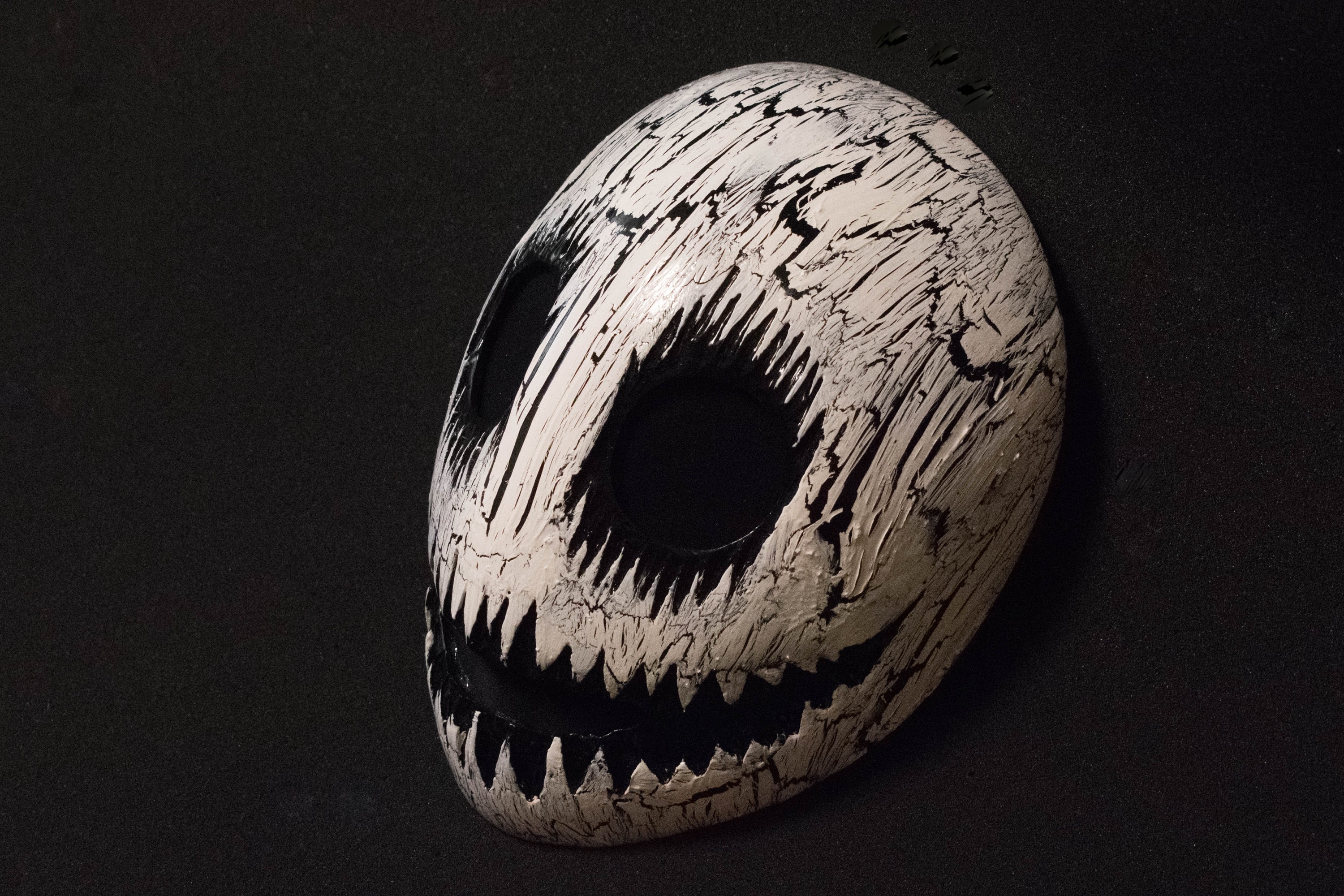 White smile mask with black cracks