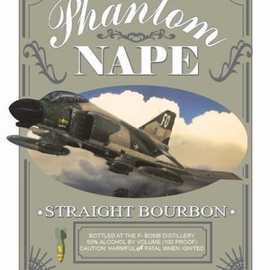 May include: A vintage-style illustration of a fighter jet with the text "Phantom NAPE Straight Bourbon" and "Bottled at the F-Bomb Distillery 50% Alcohol by Volume (100 Proof) Caution: Harmful or Fatal When Ignited".