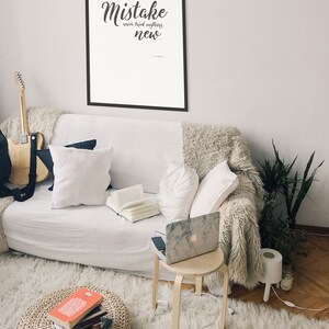 May include: A framed inspirational quote on a white background with black text that reads "A person who never made a mistake never tried anything new."