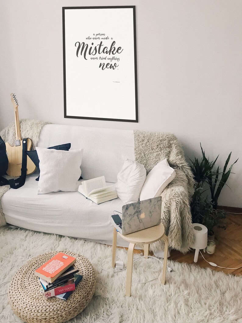 May include: A framed inspirational quote on a white background with black text that reads "A person who never made a mistake never tried anything new."