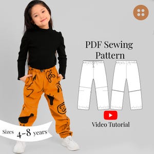 May include: A young girl wearing a black long-sleeved top and orange pants with black graphic designs. The image also includes a PDF sewing pattern for pants and text that reads "Sizes 4-8 years" and "Video Tutorial."