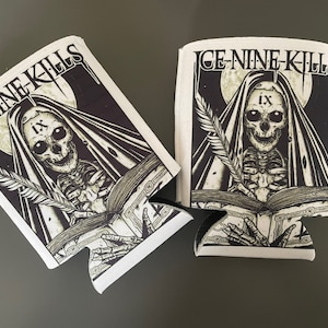 May include: Two black and white can coolers with the band name "ICE NINE KILLS" and the Roman numeral "IX" printed on them. The design features a skeleton wearing a hooded robe and holding a quill pen and a book.