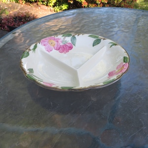May include: Oval, divided serving dish with a floral design. The dish is white with three sections and a scalloped edge. Pink flowers and green leaves are painted around the rim, with a gold-colored trim.