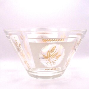 May include: Clear glass bowl with a wide, angled design. The bowl features a frosted band with a gold wheat design in the center and along the rim. The wheat design is repeated on the sides of the bowl. A vintage kitchenware item.