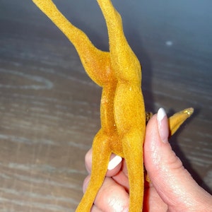 Pode incluir: Uma figura de rena vintage de feltro amarelo com uma cauda de glitter dourado. A rena est&aacute; em p&eacute; sobre suas patas traseiras com as patas dianteiras levantadas no ar.