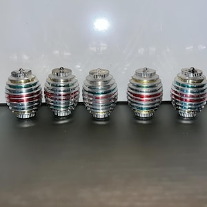 Op de afbeelding: Vijf zilveren kerstballen met rode, groene en gouden strepen. De ballen zijn rond en hebben een glanzende afwerking.