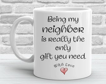 Könnte beinhalten: Weiße Keramik-Kaffeetasse mit schwarzem Text, der lautet "Mein Nachbar zu sein ist wirklich das einzige Geschenk, das du brauchst. Mit Liebe" und einem rosa Herzen.