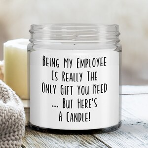 May include: A white candle in a clear glass jar with a black label that reads "Being my employee is really the only gift you need... but here's a candle!"
