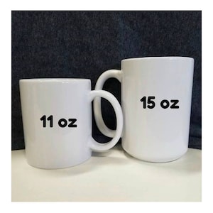 May include: Two white ceramic mugs, one is 11 oz and the other is 15 oz.