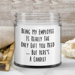 May include: A white candle in a glass jar with a black label that reads "Being my employee is really the only gift you need... but here's a candle!"