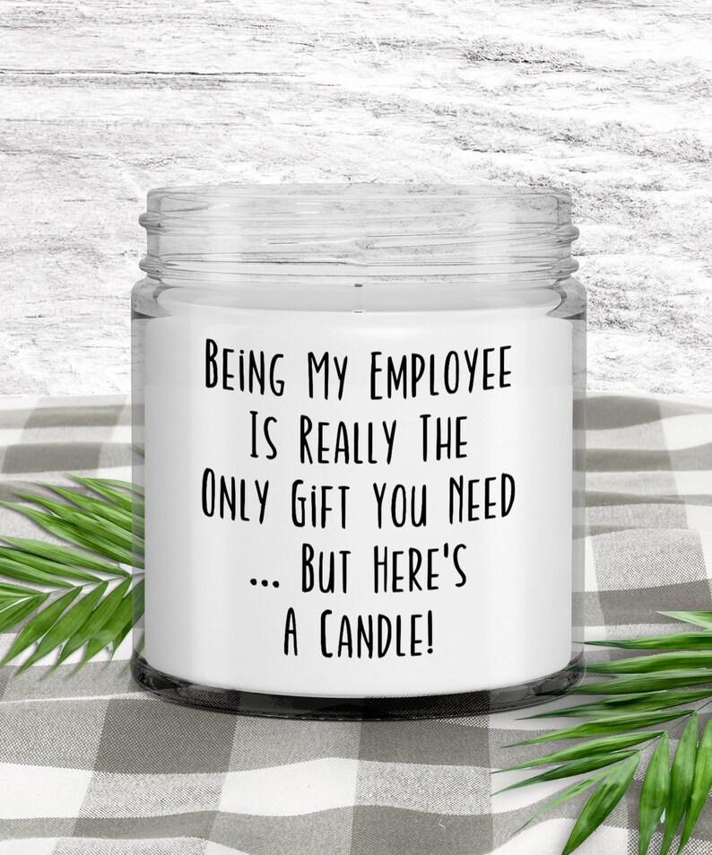 May include: A white candle in a glass jar with a black label that reads "Being my employee is really the only gift you need... but here's a candle!"